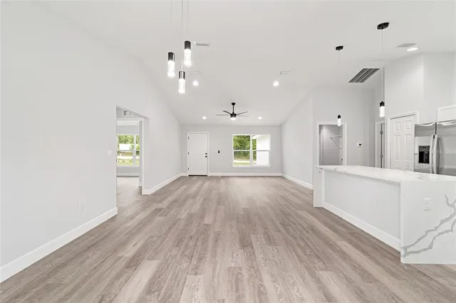 a view of an empty room and window with wooden floor