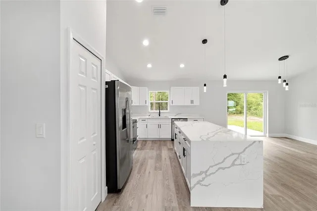 a open kitchen with white cabinets and stainless steel appliances