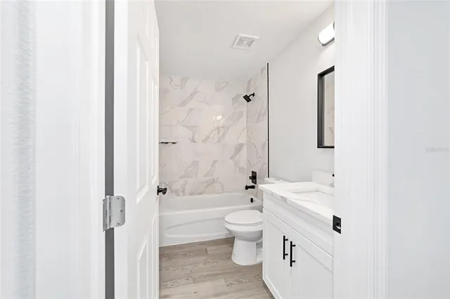 a bathroom with a tub sink toilet and a mirror