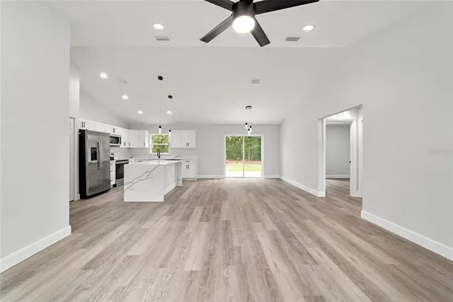 a view of a kitchen with wooden floor and a ceiling fan