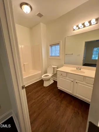 a bathroom with a double vanity sink a mirror and a bathtub