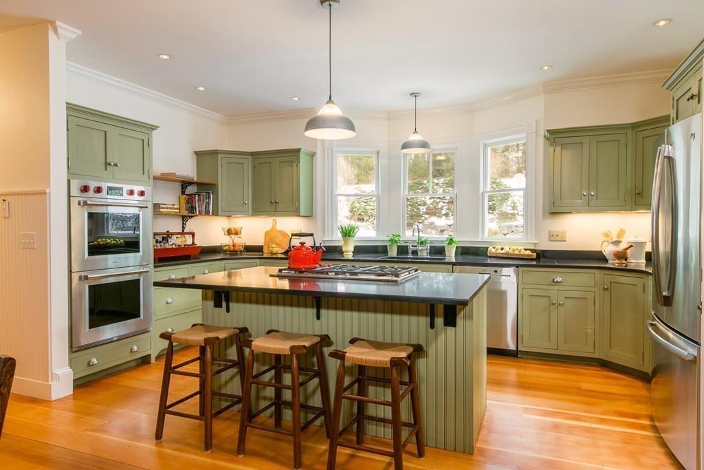 106 Koning Farm Road Carlisle, MA 01741 - Photo 3 of 39 a kitchen with stainless steel appliances granite countertop a stove top oven a sink dishwasher a dining table and chairs with wooden floor