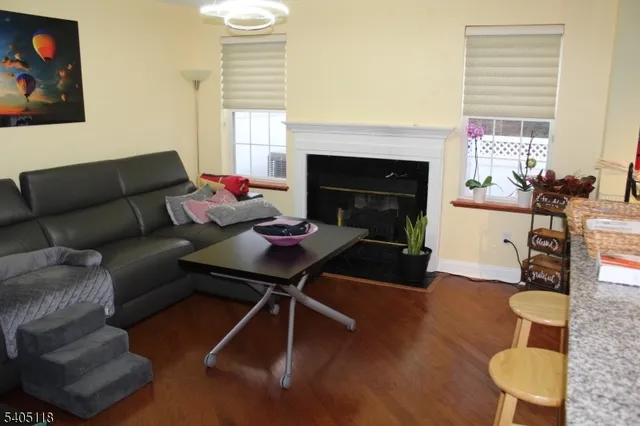 a kitchen with stainless steel appliances granite countertop a sink dishwasher a stove a dining table and chairs with wooden floor