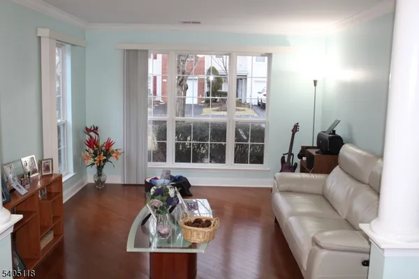 a living room with furniture two window and a flat screen tv