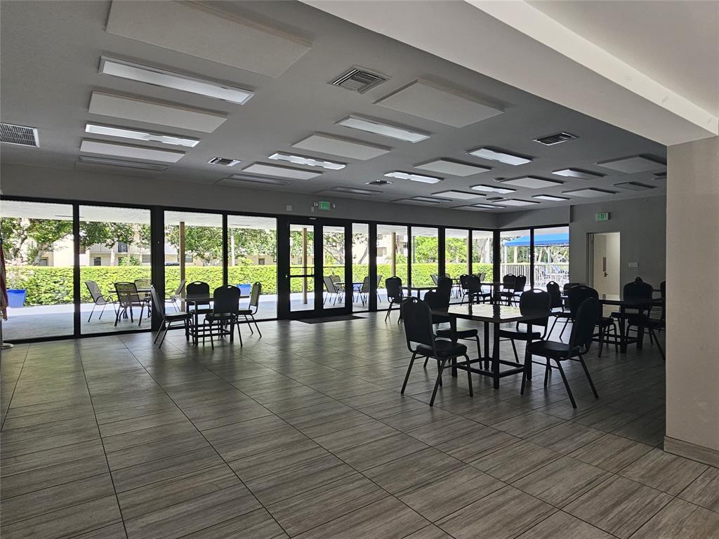 2450 DC Country Club Boulevard, Unit 203B Deerfield Beach, FL 33442 - Photo 14 of 19 a dining room with furniture floor to ceiling windows and plants