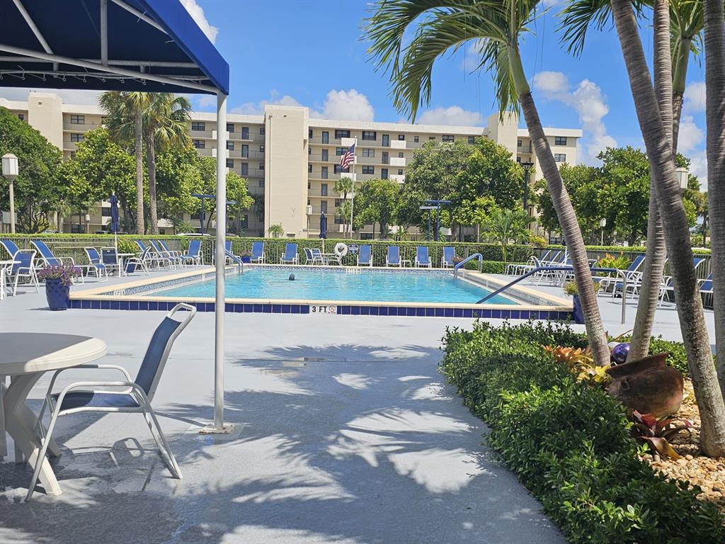 2450 DC Country Club Boulevard, Unit 203B Deerfield Beach, FL 33442 - Photo 18 of 19 a view of a swimming pool with a porch