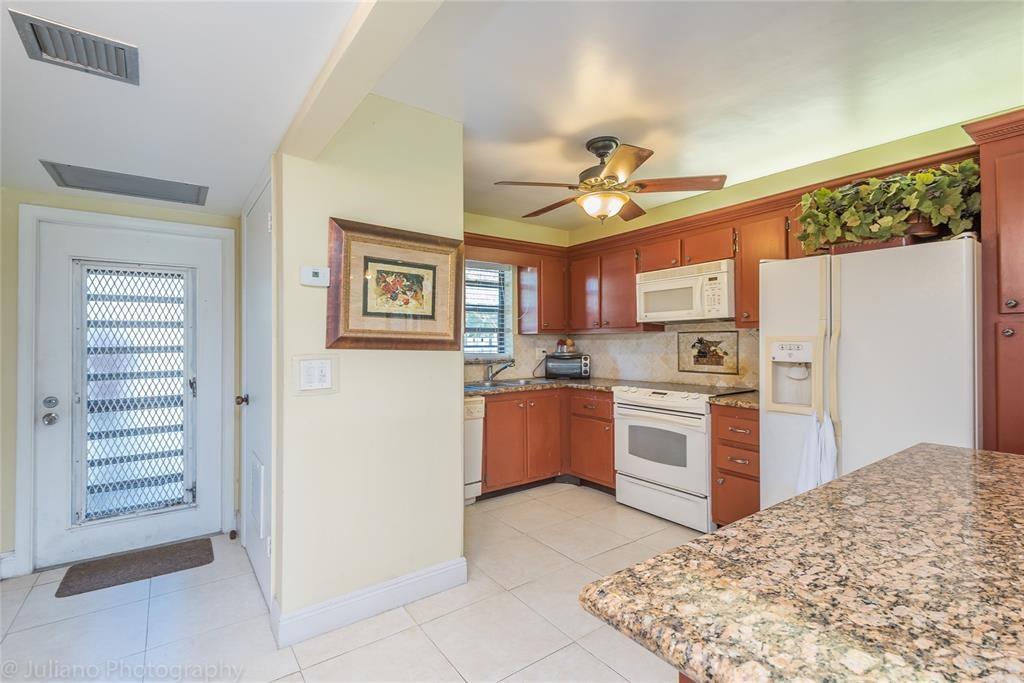 2450 DC Country Club Boulevard, Unit 203B Deerfield Beach, FL 33442 - Photo 5 of 19 a kitchen with a refrigerator and a sink