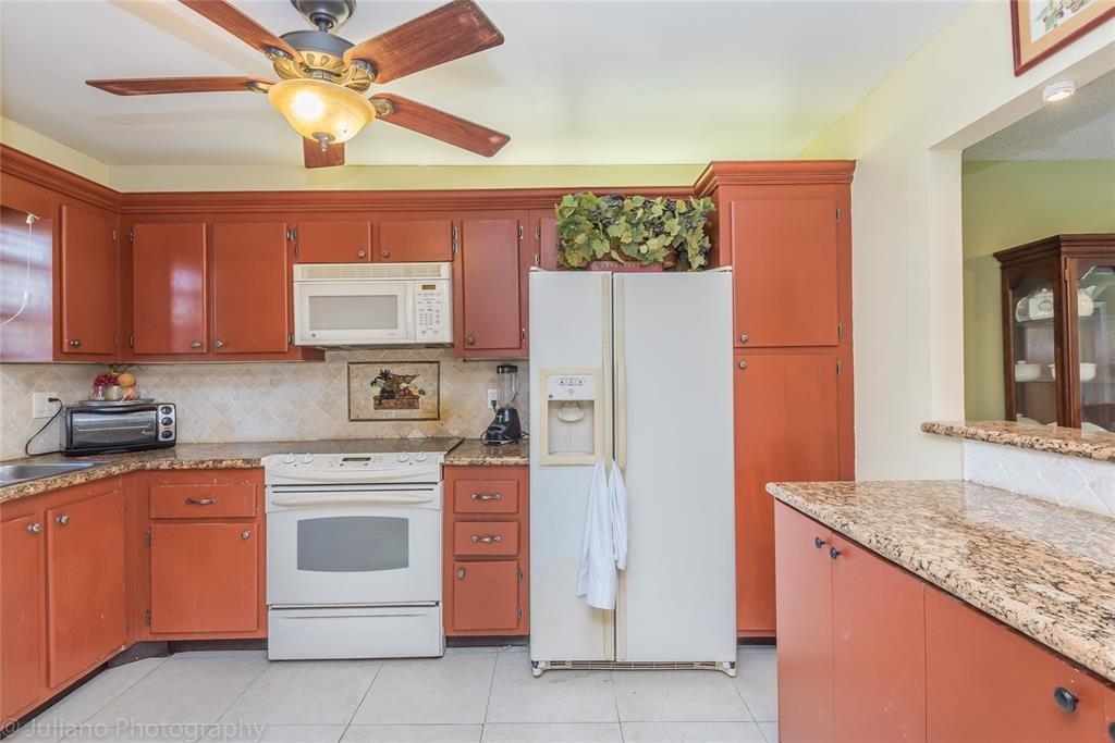 2450 DC Country Club Boulevard, Unit 203B Deerfield Beach, FL 33442 - Photo 6 of 19 a kitchen with stainless steel appliances granite countertop a refrigerator and a stove top oven