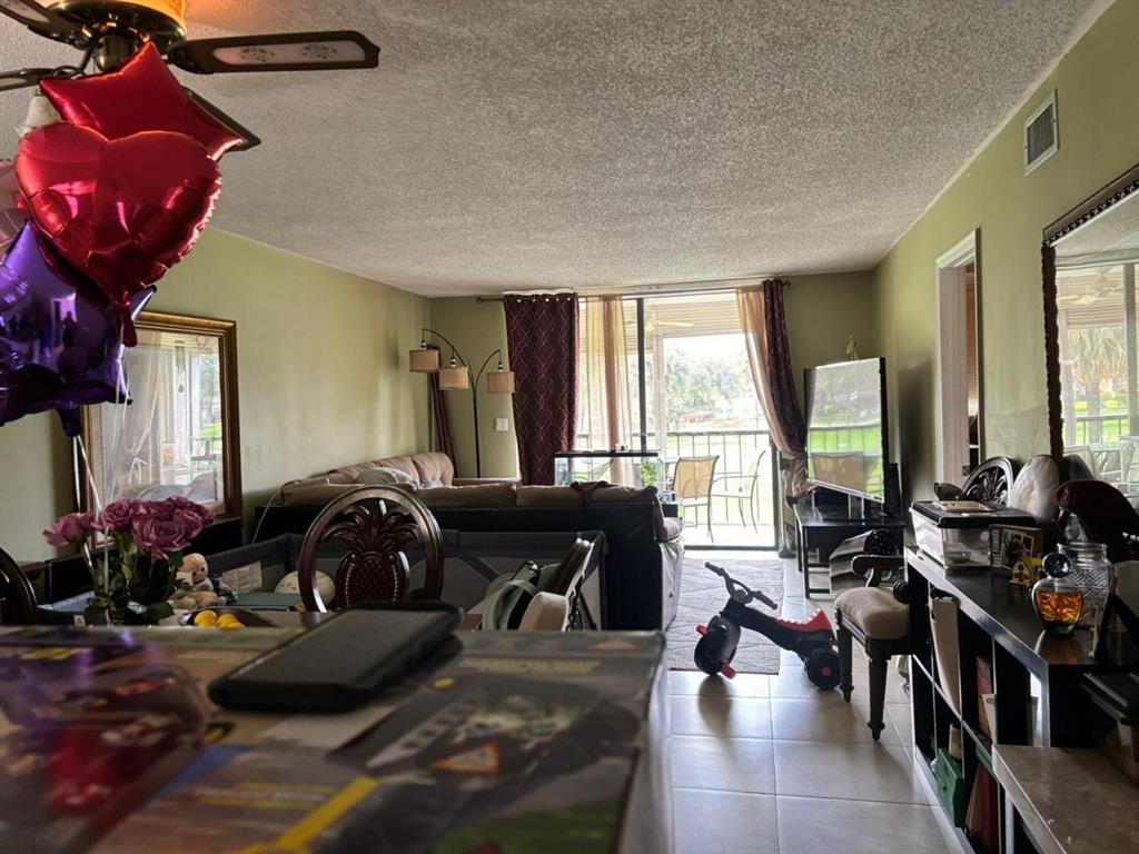 2450 DC Country Club Boulevard, Unit 203B Deerfield Beach, FL 33442 - Photo 9 of 19 a living room with furniture and large windows