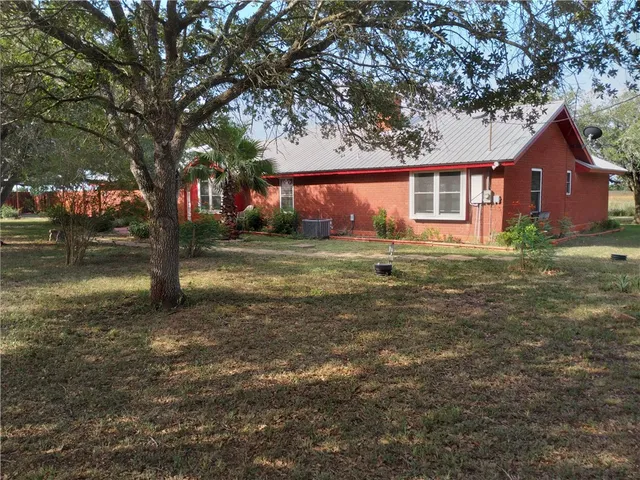 a view of a backyard with plants and wooden fence