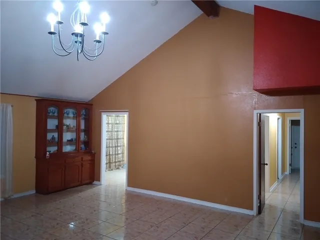 a view of an empty room with wooden floor and a fireplace