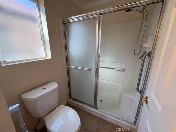 a white toilet sitting next to a shower
