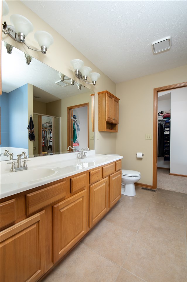11003 Chicory Ridge Way Roscoe, IL 61073 - Photo 17 of 34 a spacious bathroom with a granite countertop sink mirror and toilet