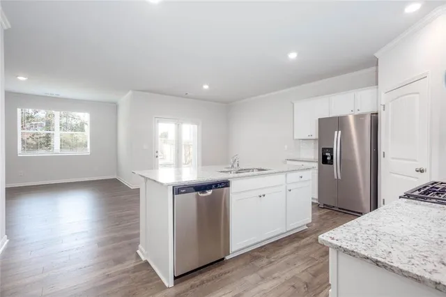 a kitchen with stainless steel appliances granite countertop a sink stove and refrigerator