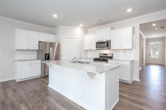 a kitchen with refrigerator a stove top oven a sink and cabinets