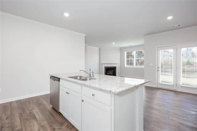 a room with a sink wooden floor and glass door