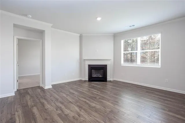 wooden floor fireplace and windows in an empty room