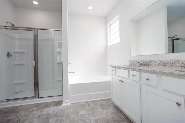 a bathroom with a granite countertop sink and shower