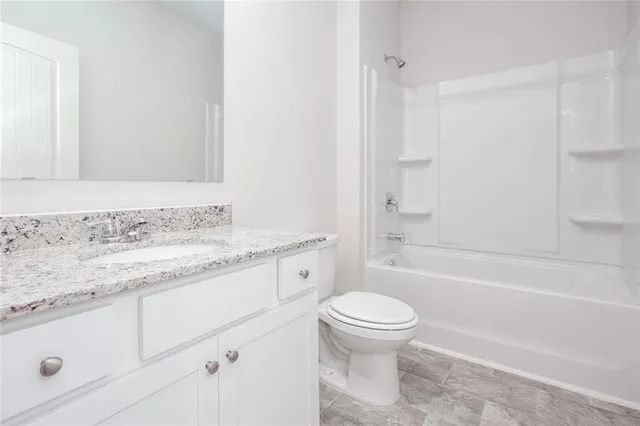 a bathroom with a granite countertop sink a toilet and a bathtub