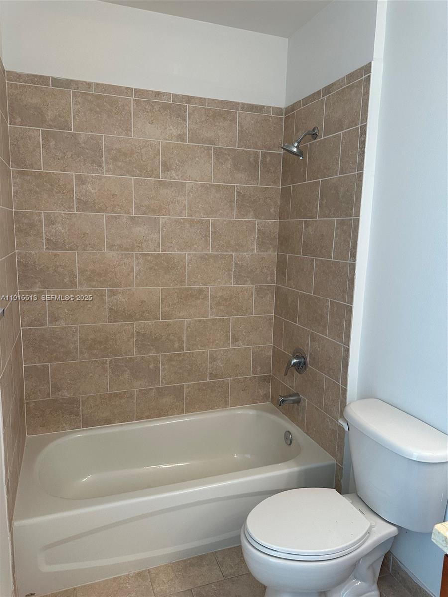 1723 Southwest 2nd Avenue, Unit PH09 Miami, FL 33129 - Photo 18 of 21 a white toilet and tub sitting next to a bathroom sink