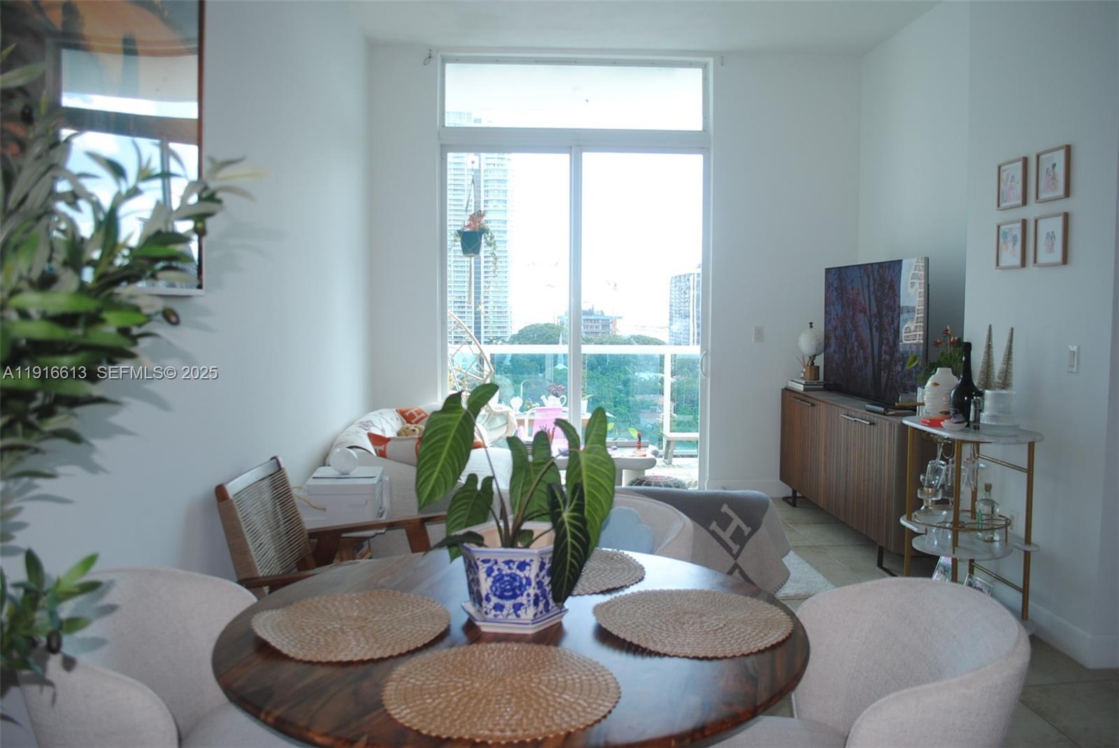 1723 Southwest 2nd Avenue, Unit PH09 Miami, FL 33129 - Photo 7 of 21 a dining room with furniture a potted plant and a chandelier