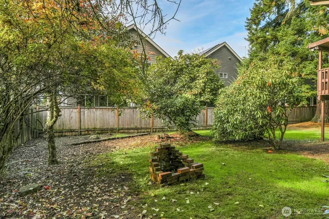 a backyard of a house with plants and large trees