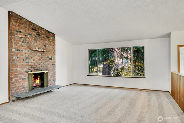 wooden floor fireplace and windows in an empty room