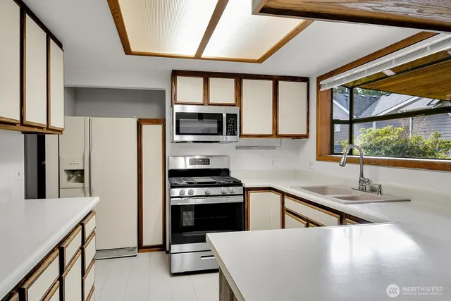 a kitchen with stainless steel appliances kitchen island granite countertop a stove a sink and a microwave