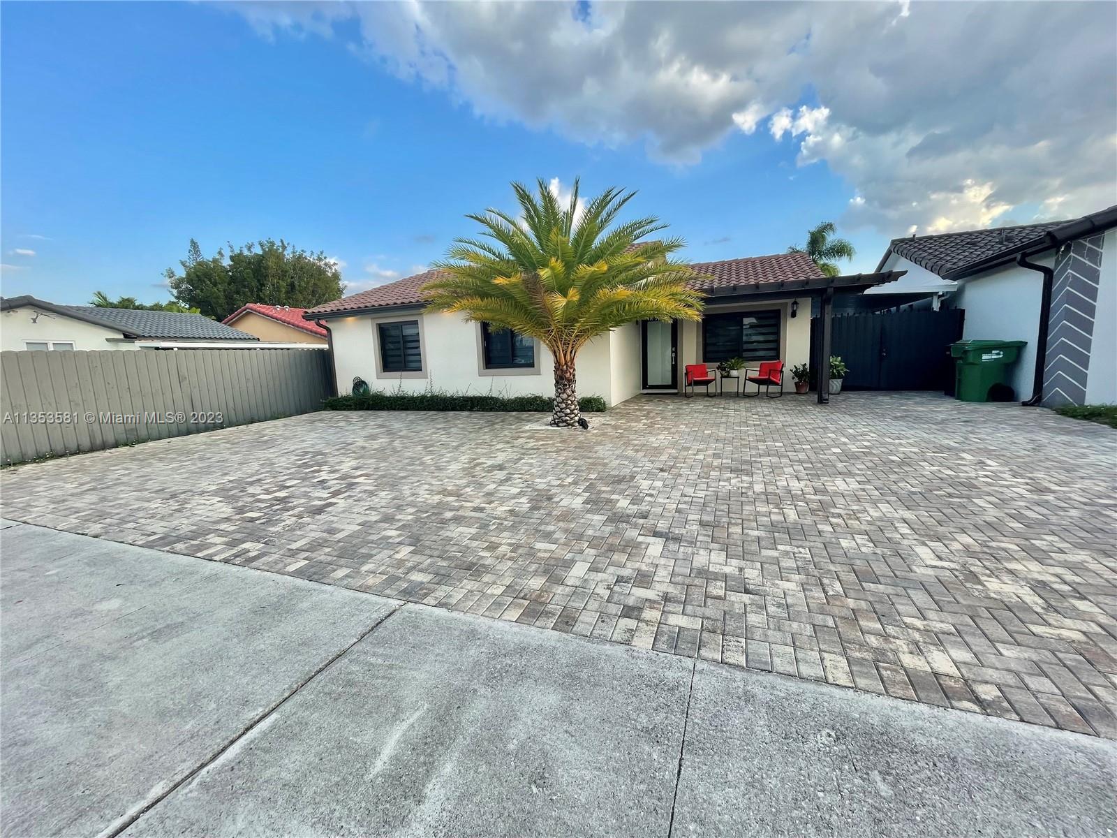 13850 Southwest 22nd Street Miami, FL 33175 - Photo 2 of 23 a view of a house with a yard and garage