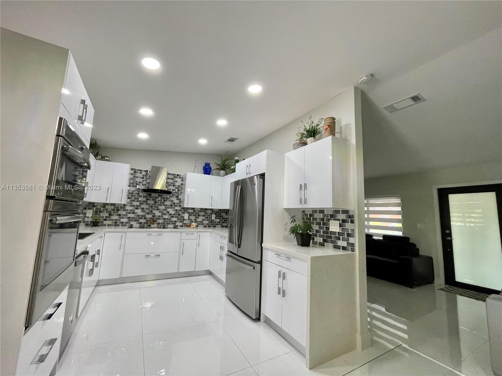 13850 Southwest 22nd Street Miami, FL 33175 - Photo 3 of 23 a kitchen with stainless steel appliances kitchen island granite countertop a refrigerator and stove