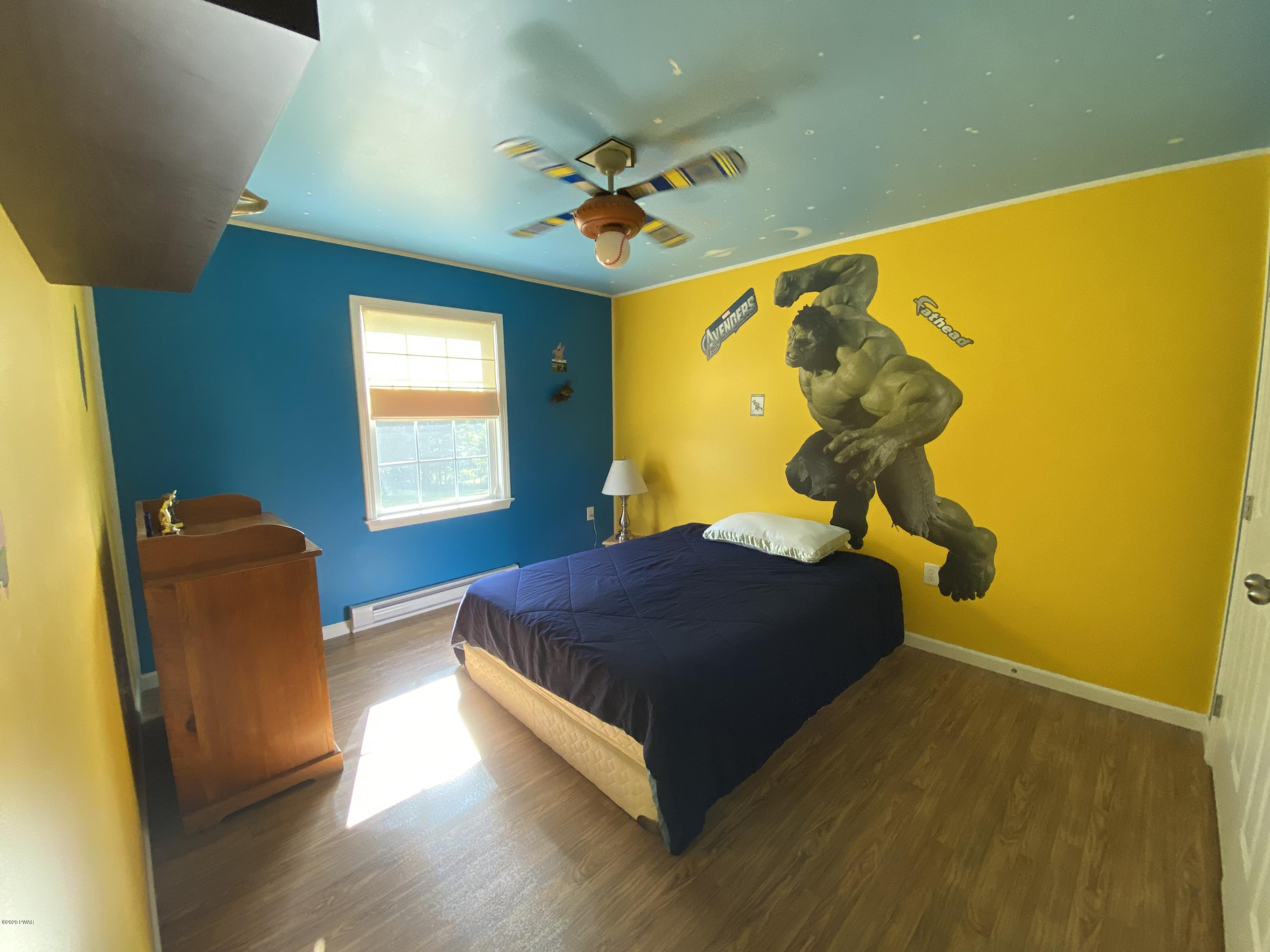 283 Mill Brook Road Waymart, PA 18472 - Photo 11 of 30 a bedroom with a bed and wooden floor