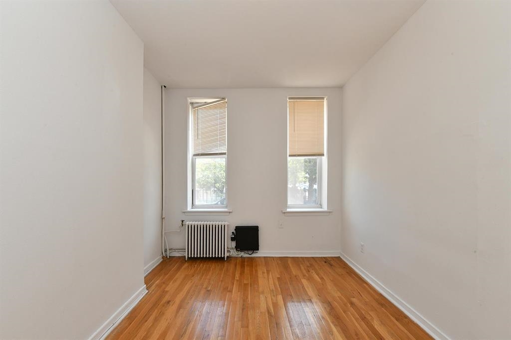 118 Adams Street, Unit 6 Hoboken, NJ 07030 - Photo 11 of 17 an empty room with wooden floor and windows