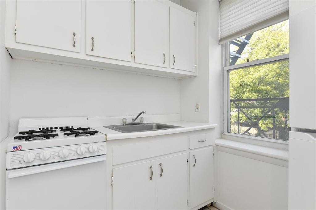 118 Adams Street, Unit 6 Hoboken, NJ 07030 - Photo 13 of 17 a kitchen with granite countertop white cabinets and a stove