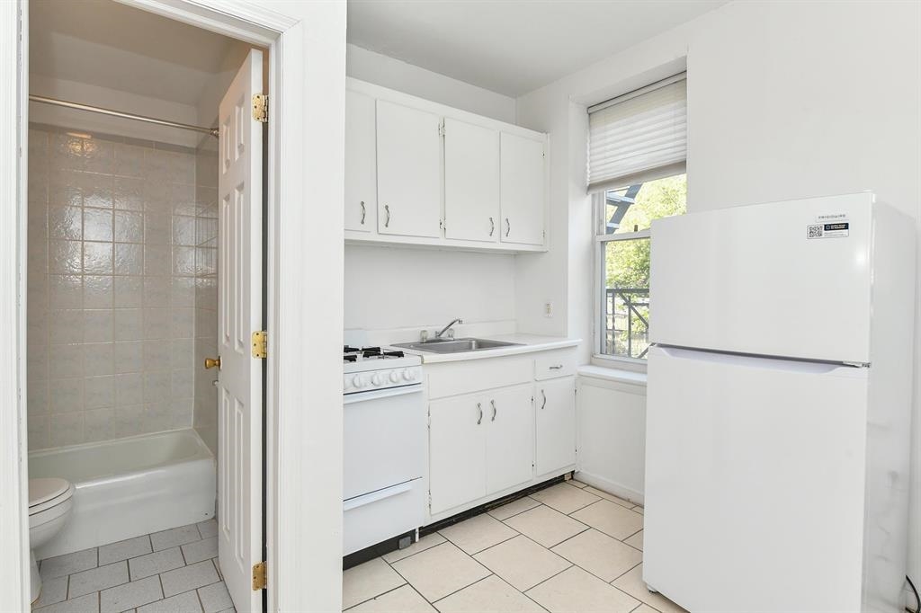 118 Adams Street, Unit 6 Hoboken, NJ 07030 - Photo 6 of 17 a kitchen with white cabinets and white appliances