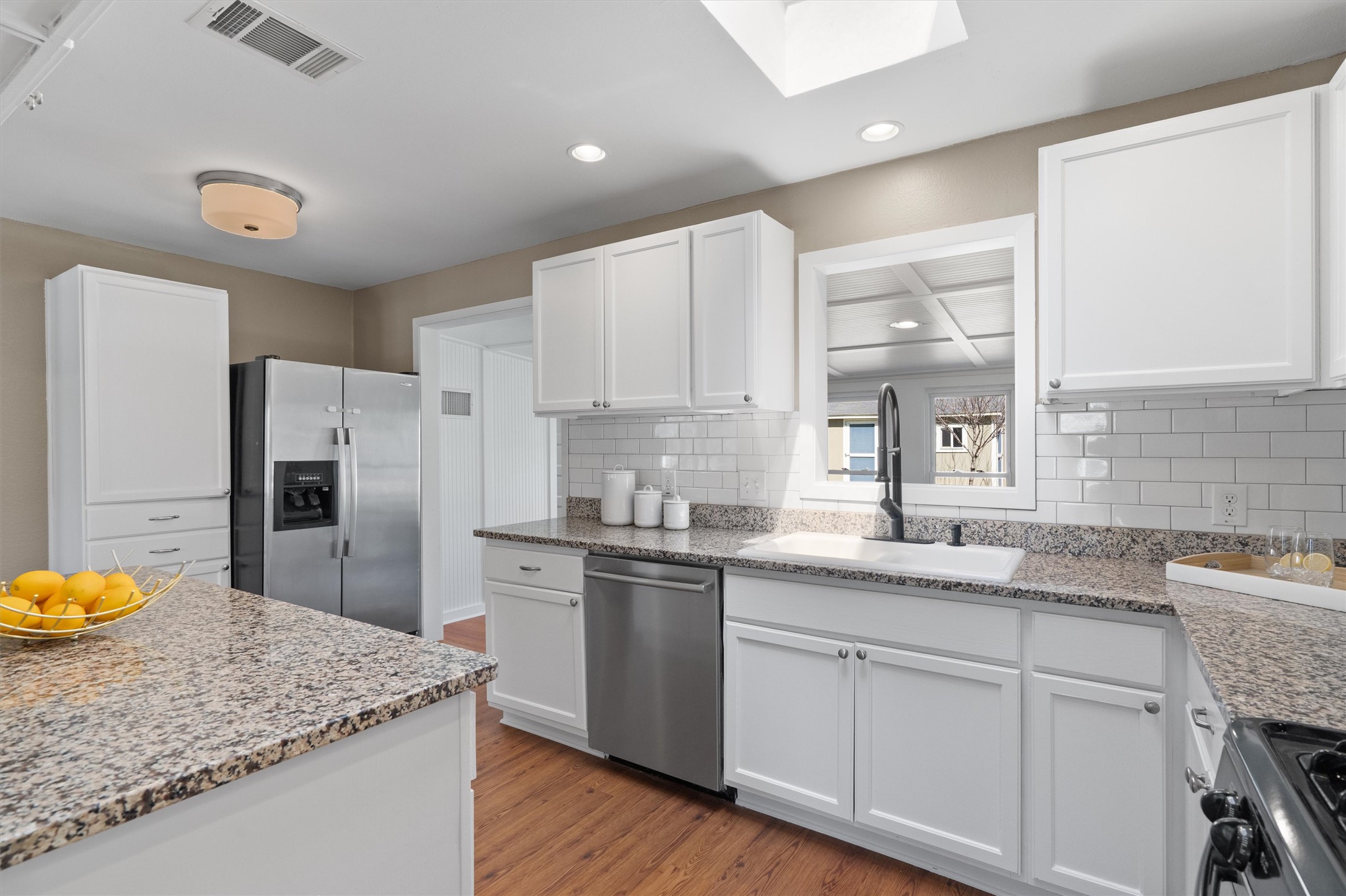 1904 Morrow Street Austin, TX 78757 - Photo 12 of 28 The kitchen features white cabinetry, granite counters, subway tile backsplash and SS appliances.