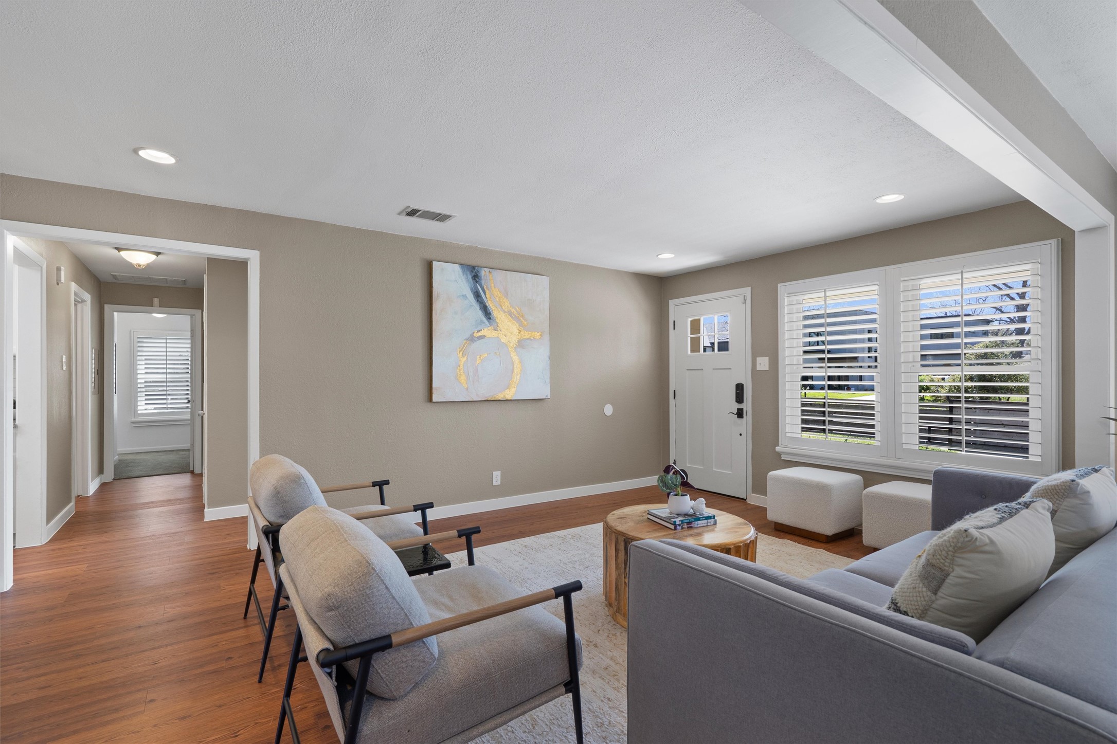 1904 Morrow Street Austin, TX 78757 - Photo 6 of 28 Plantation shutters, warm flooring, and natural light give this front living space a clean, welcoming feel.