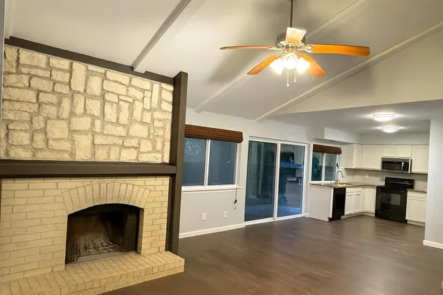 a view of an empty room with a fireplace and a window