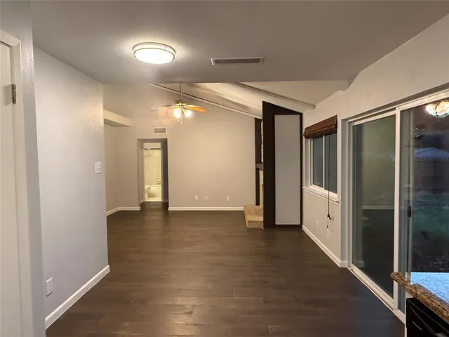 a view of a hallway with stainless steel appliances