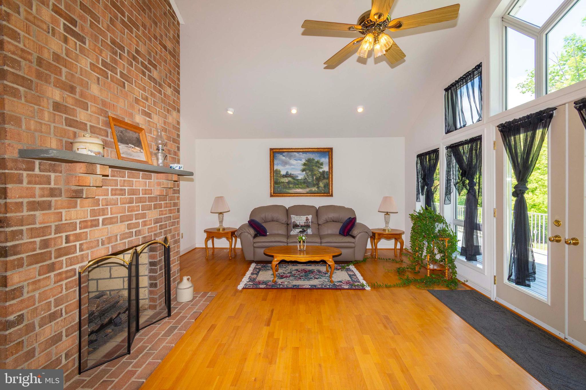 6000 Haleys Mill Road Spotsylvania, VA 22551 - Photo 17 of 85 a living room with furniture a flat screen tv and a floor to ceiling window