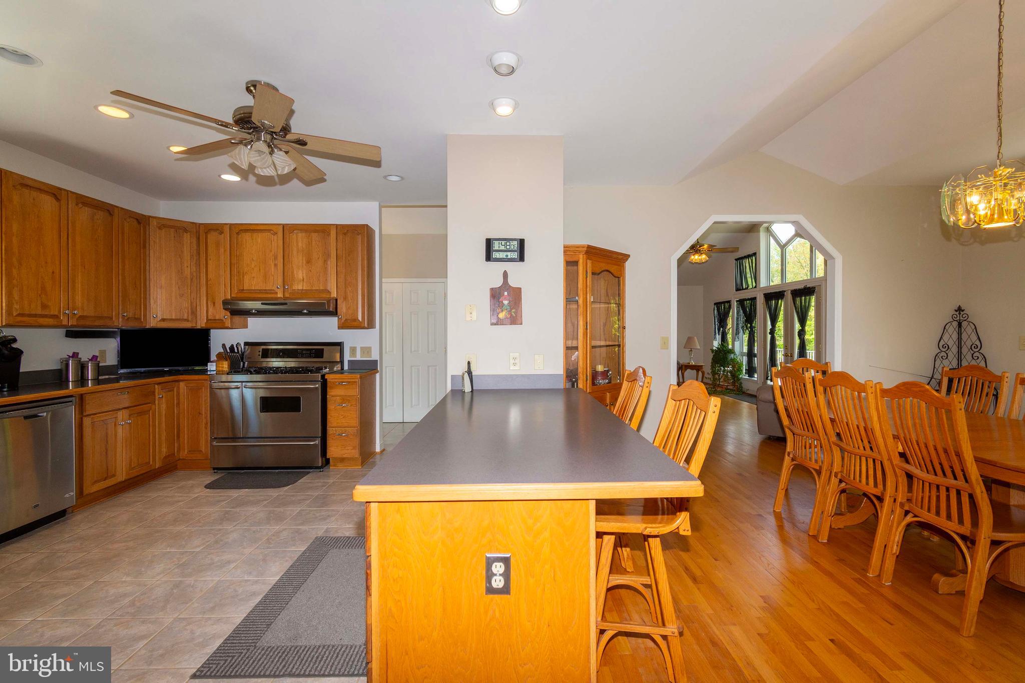 6000 Haleys Mill Road Spotsylvania, VA 22551 - Photo 28 of 85 a kitchen with stainless steel appliances granite countertop a stove a refrigerator a sink a dining table and chairs with wooden floor