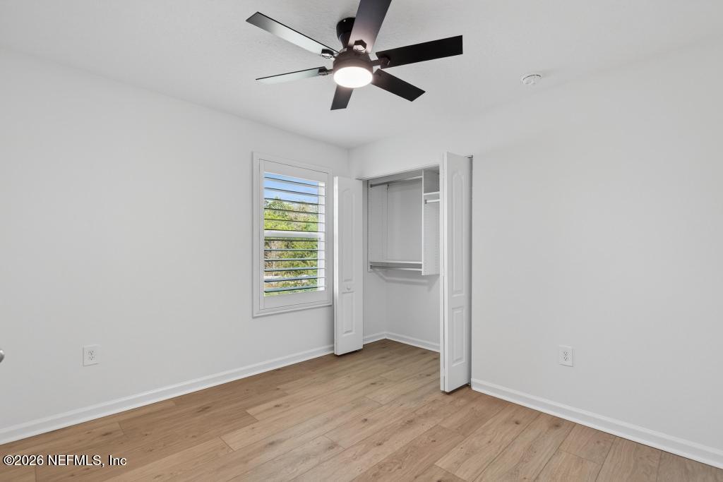 45 Seaport Breeze Road St. Augustine, FL 32095 - Photo 46 of 88 an empty room with wooden floor ceiling fan and windows