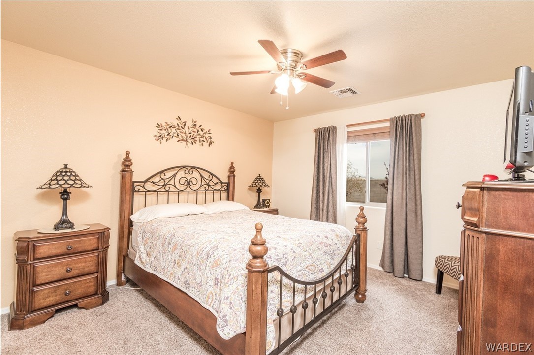 4292 East Cane Ranch Road Kingman, AZ 86401 - Photo 20 of 34 a bedroom with a bed and a chandelier