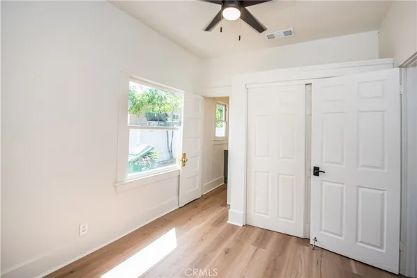 a view of hallway with window and wooden floor