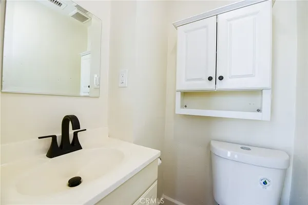 a bathroom with a sink a toilet and mirror