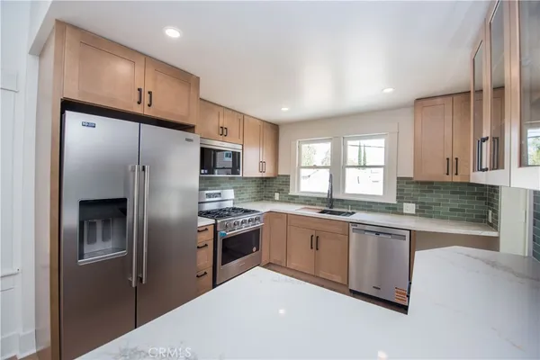 a kitchen with stainless steel appliances granite countertop a refrigerator sink and cabinets