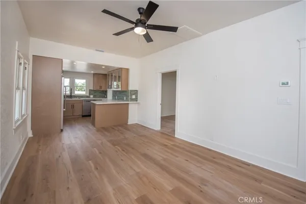 a kitchen with a wooden floor and stainless steel appliances