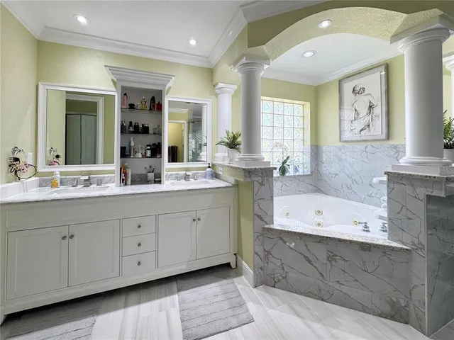 a spacious bathroom with double sink a large mirror and a bathtub