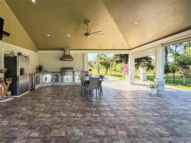 a view of a kitchen with stainless steel appliances a large window a rug and a view of living room