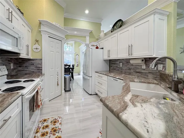 a kitchen with stainless steel appliances granite countertop a sink stove and cabinets