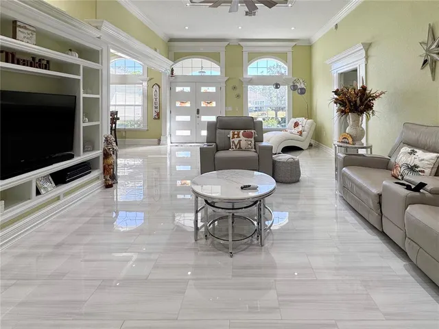 a living room with furniture a flat screen tv and a floor to ceiling window
